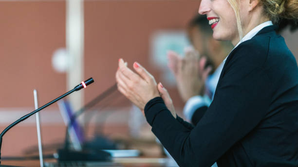 A female committee member applauding at a conference in the board room